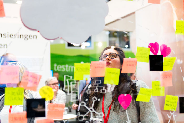 Kvinna vid tavla med post-it lappar